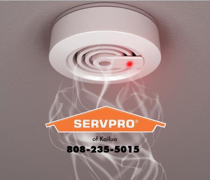 Smoke is rising up towards a smoke alarm mounted on a ceiling.